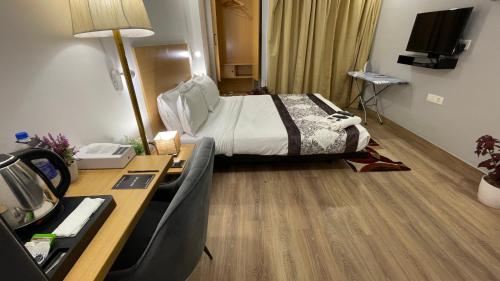 a hotel room with a bed and a desk at Saltstayz Express - Golf Course Road & DLF Phase-1 in Gurgaon