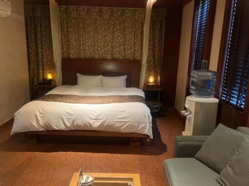 a bedroom with a bed and a couch at Hulamoon in Maizuru