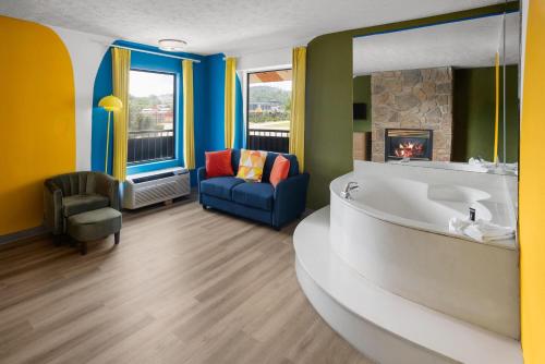 a bathroom with a tub and a chair and a fireplace at Days Inn By Wyndham Pigeon Forge South in Pigeon Forge