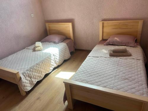 two twin beds in a room with wooden floors at Jafaridzeebtan in Oni