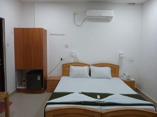 a bedroom with a bed and a fan at Cross Bill Beach Resort in Havelock Island