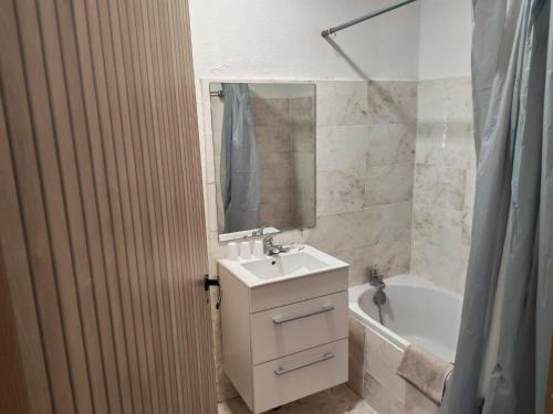 a bathroom with a sink and a bath tub at Hotel Le Bois Des Espeisses in Nîmes