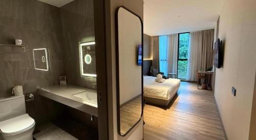 a bathroom with a toilet a sink and a bed at J HOTEL in Kampong Kiulap