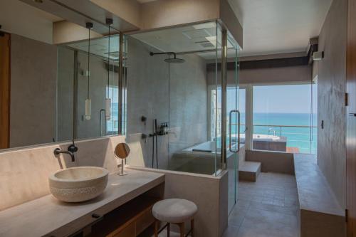 a bathroom with a sink and a shower and a tub at KAYATSUMA OKINAWA Hotel&Resort in Nakijin