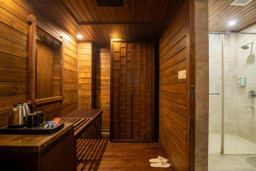 a sauna with wooden walls and a shower and a sink at TSG Aura in Neil Island