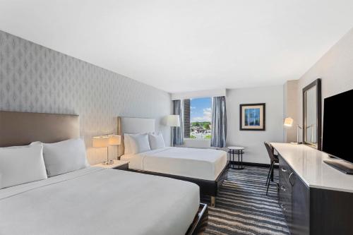 a hotel room with two beds and a flat screen tv at DoubleTree by Hilton Hotel Wilmington in Wilmington