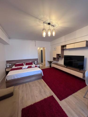 a bedroom with a large bed and a red rug at Emmaia Escape Eforie Nord in Eforie Nord