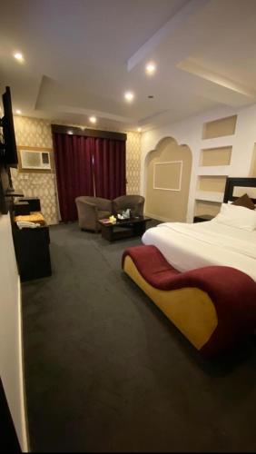 a hotel room with a bed and a living room at Al Majaridah Hotel in Al Majaridah