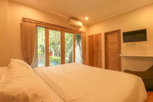 a bedroom with a large white bed and a window at Neduh House Pererenan in Pererenan
