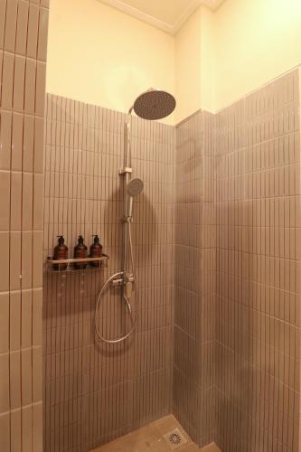 a shower with a shower head in a bathroom at Neduh House Pererenan in Pererenan