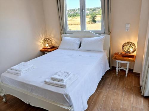 a bedroom with a white bed with a window at EuZoea Country Home 2 Nature Escape with Pool in Kapandrítion