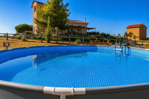 a large swimming pool with a slide in front of a house at EuZoea Country Home 2 Nature Escape with Pool in Kapandrítion