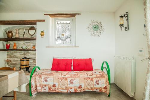 a bedroom with a bed with red pillows at Appartamento open space al civico 29 in Collestrada