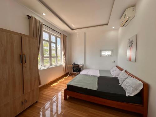 a bedroom with a bed and a large window at Hammer Homestay in Danang