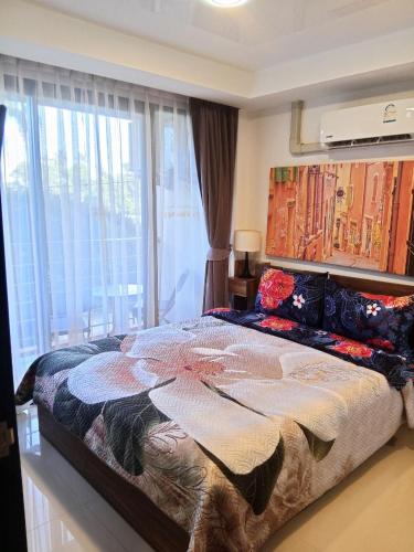a bedroom with a large bed with a large window at Vacation by the ocean in Phuket