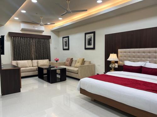 a hotel room with a bed and a couch at Hotel SR Tiruchendur in Thiruchendur