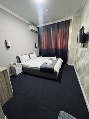a hotel room with a bed and a window at BOG'DON GRAND Hotel in Tashkent