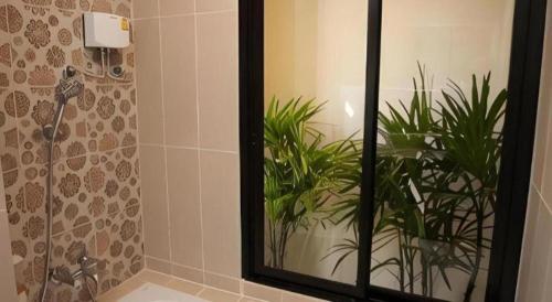 a mirror in a bathroom with a plant at Lotusland Resort in Jomtien Beach
