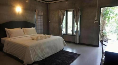a bedroom with a bed and a large window at V Valley Resort in Satun