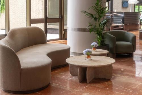 a lobby with a chair and a coffee table at Hilton Strasbourg in Strasbourg