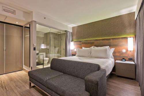 a bedroom with a bed and a couch and a bathroom at Meliá Ibirapuera in São Paulo