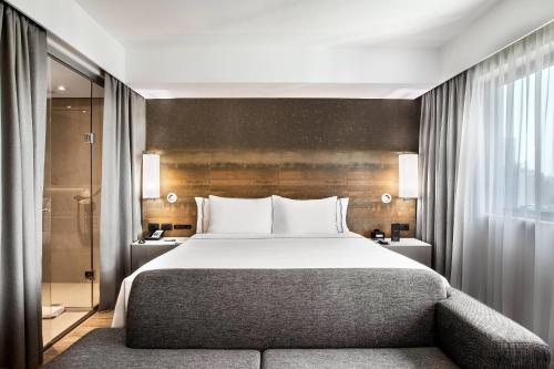 a bedroom with a large bed and a shower at Meliá Ibirapuera in São Paulo