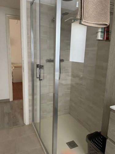 a shower with a glass door in a bathroom at The River in Fordongianus