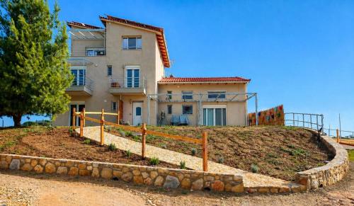 a house on a hill with a fence in front of it at EuZoea Country Home 3 Nature Escape with Pool in Kapandrítion