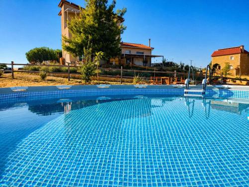 a swimming pool in front of a house at EuZoea Country Home 3 Nature Escape with Pool in Kapandrítion