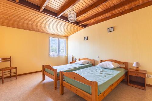 two beds in a room with yellow walls at Duplex N°1 - Résidence Balnéaire in Le Port-des-Barques