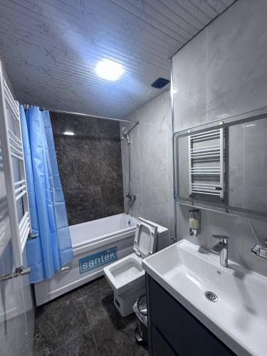a bathroom with a sink and a toilet and a tub at MUXSIN s in Bukhara