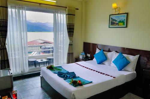 a bedroom with a bed and a window with a view at Hotel Kunja in Pokhara