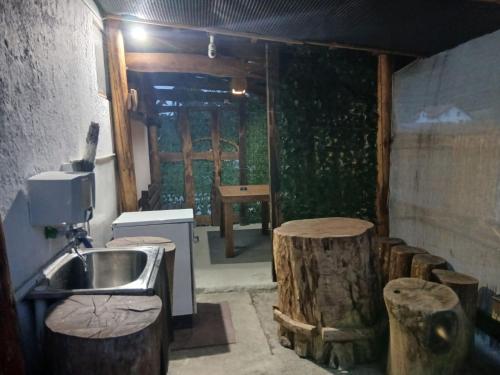 a bathroom with a sink and some wooden logs at Apartman Retro 2 in Žepče