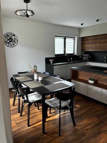 a kitchen with a black table and chairs in it at Prázdninový dům MAJKA in Mosty u Jablunkova