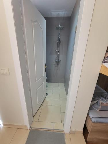 a hallway with a white door and a tile floor at AG Hotel in Dhërmi