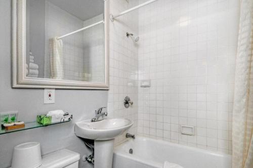 a white bathroom with a sink and a toilet at The Monarch Hotel in San Francisco