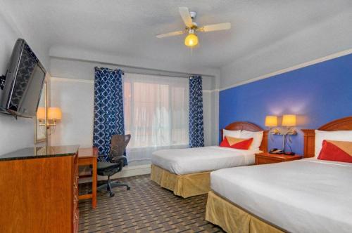 a hotel room with two beds and a desk at The Monarch Hotel in San Francisco