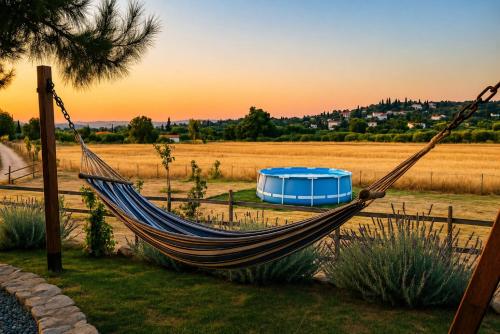 a hammock in a field with a blue tent at EuZoea Country Home 1 Nature Escape with Pool in Kapandrítion