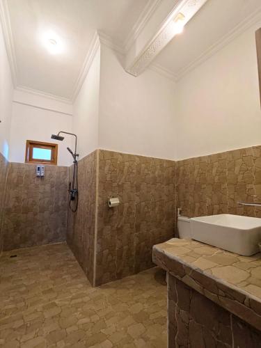 a bathroom with a bath tub and a shower at Tetebatu Sunset House in Tetebatu