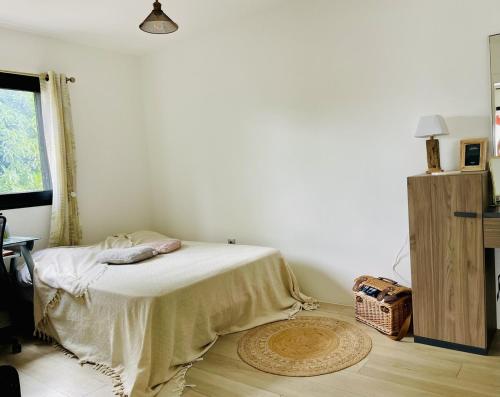 a bedroom with a bed with a blanket on it at La Kazbanon in La Possession