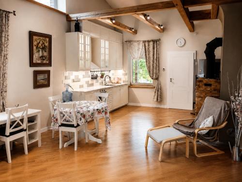 a kitchen and dining room with a table and chairs at Unique Mailo House & Cottage in Riga