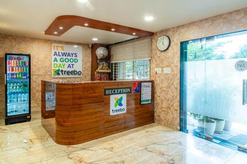 a restaurant with a counter and a clock on the wall at Treebo Ten Eleven Grand, Scheme 78 in Indore