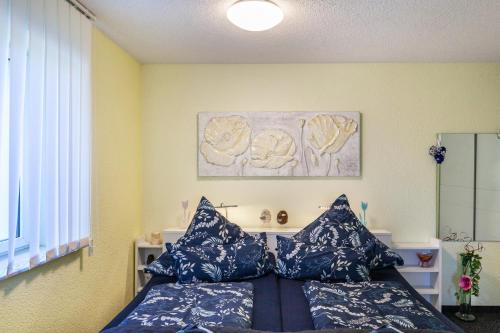 a bedroom with a bed with blue pillows at Ferienwohnung Elbtalblick in Weinböhla