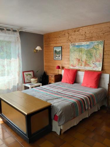 a bedroom with a large bed with red pillows at Karibu Normandy in Saint-Désir