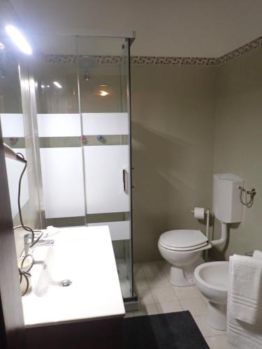 a bathroom with a shower and a toilet and a sink at Nidus in Aulla