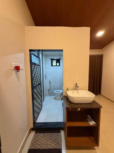 a bathroom with a sink and a toilet at WKND Casa in Panchgani
