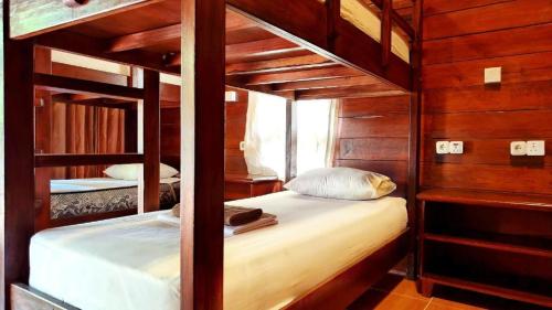 two bunk beds in a room with wooden walls at Gili Buana Hostel & Backpackers Gili Air in Gili Islands