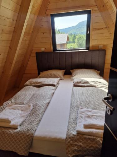 two beds in a room with a window at Etno Selo Relax in Šipovo
