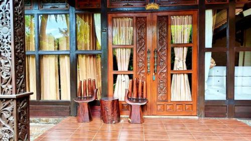 a room with two chairs in front of a door at Gili Buana Hostel & Backpackers Gili Air in Gili Islands