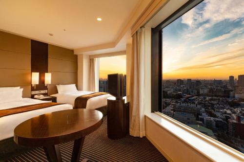 a hotel room with two beds and a large window at Shinagawa Prince Hotel in Tokyo